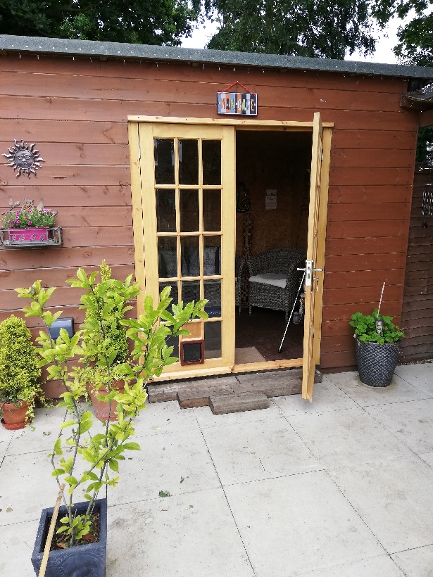 Exterior wooden double doors with glass windows.